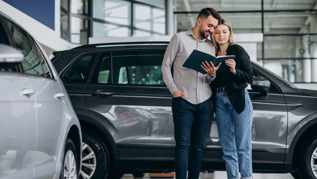 Молодая пара выбирает машину.