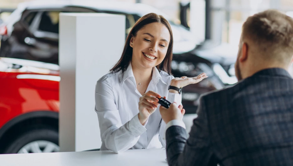 Девушка получает ключи от автомобиля.