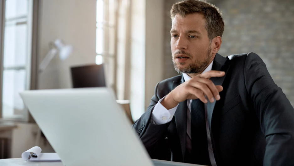 Мужчина изучает информацию на ноутбуке.