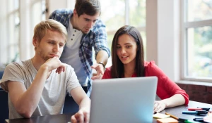 Люди работают за ноутбуком.