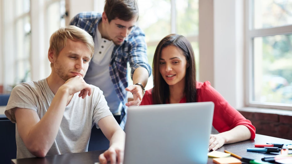 Люди работают за ноутбуком.