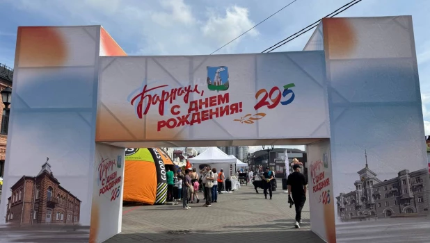 На улице Мало-Тобольской люди начинают собираться для празднования Дня города.