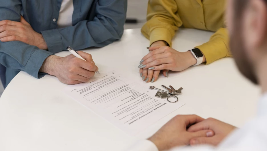 Сделка с недвижимостью. Мужчина подписывает документы.