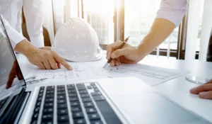 Специалисты работают с чертежами.