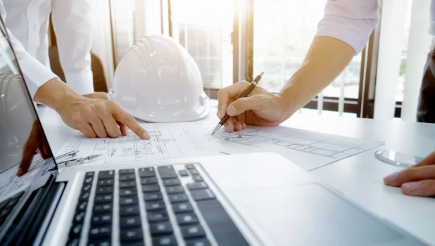 Специалисты работают с чертежами.