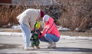 Молодая мама гуляет с ребенком.