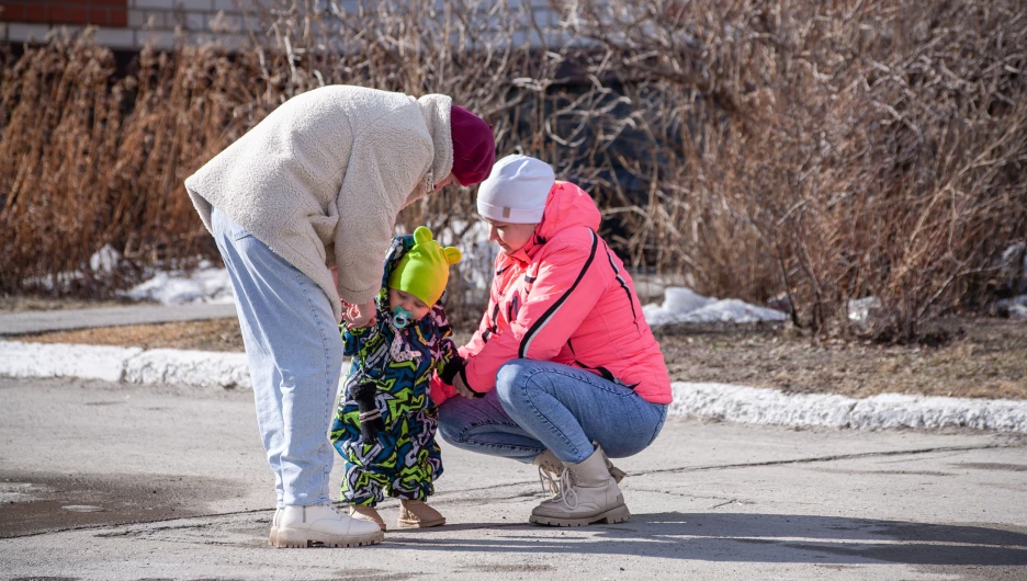 Молодая мама гуляет с ребенком.