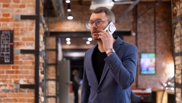 Молодой человек разговаривает по мобильному телефону.