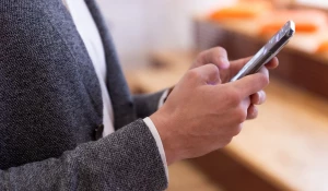 Мужчина держит в руках телефон.