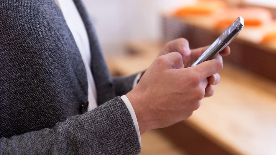 Мужчина держит в руках телефон.