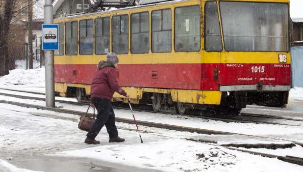 Трамвай, женщина с стростью, прохожий. 