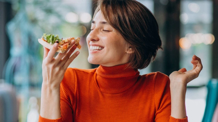 Девушка смакует еду.